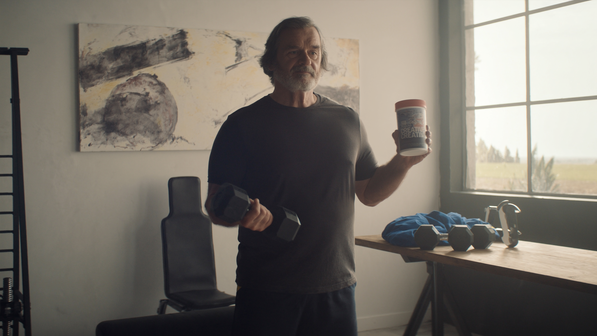 Homem acima dos 50 anos fazendo exercício com halteres e suplemento de creatina