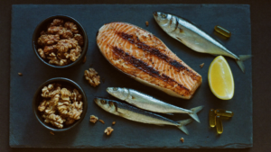 Ômega 3: salmão, sardinha, nozes e cápsulas de óleo de peixe — fontes de EPA e DHA